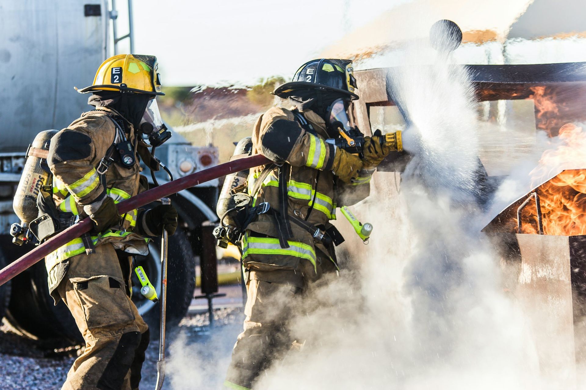 Firefighters in protective gear spraying water